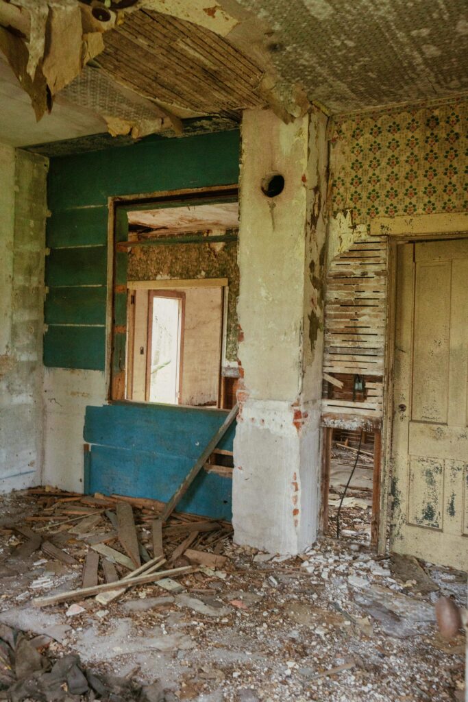 Living room with clutter and visible damage — common situation when trying to sell a distressed house